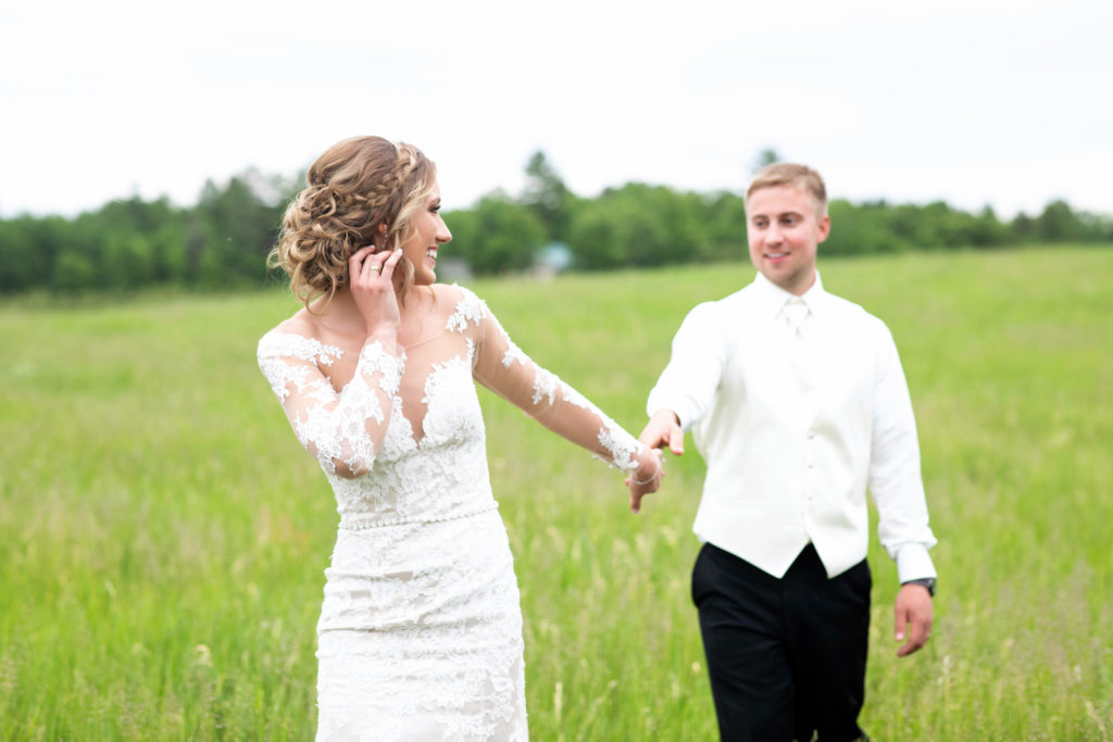 a bride and groom in a field on their wedding day in Minnesota